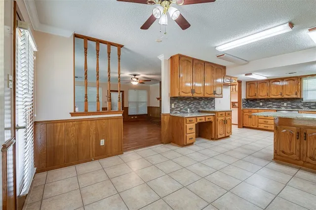 a kitchen with granite countertop a stove a sink a refrigerator and cabinets