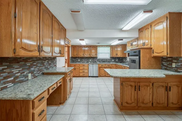 a kitchen with stainless steel appliances granite countertop a sink counter space cabinets and a large window