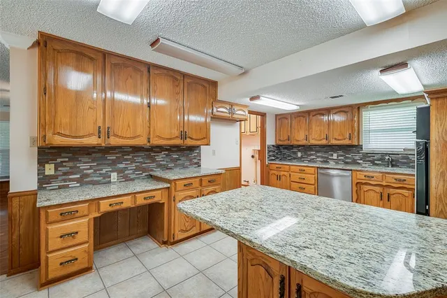 a kitchen with granite countertop wooden cabinets and white appliances