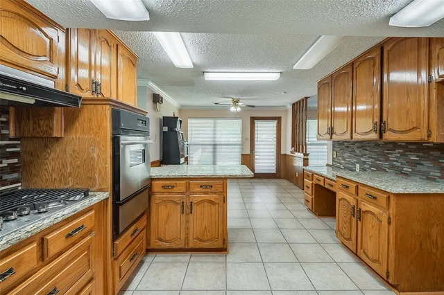a large kitchen with stainless steel appliances granite countertop a stove and a sink