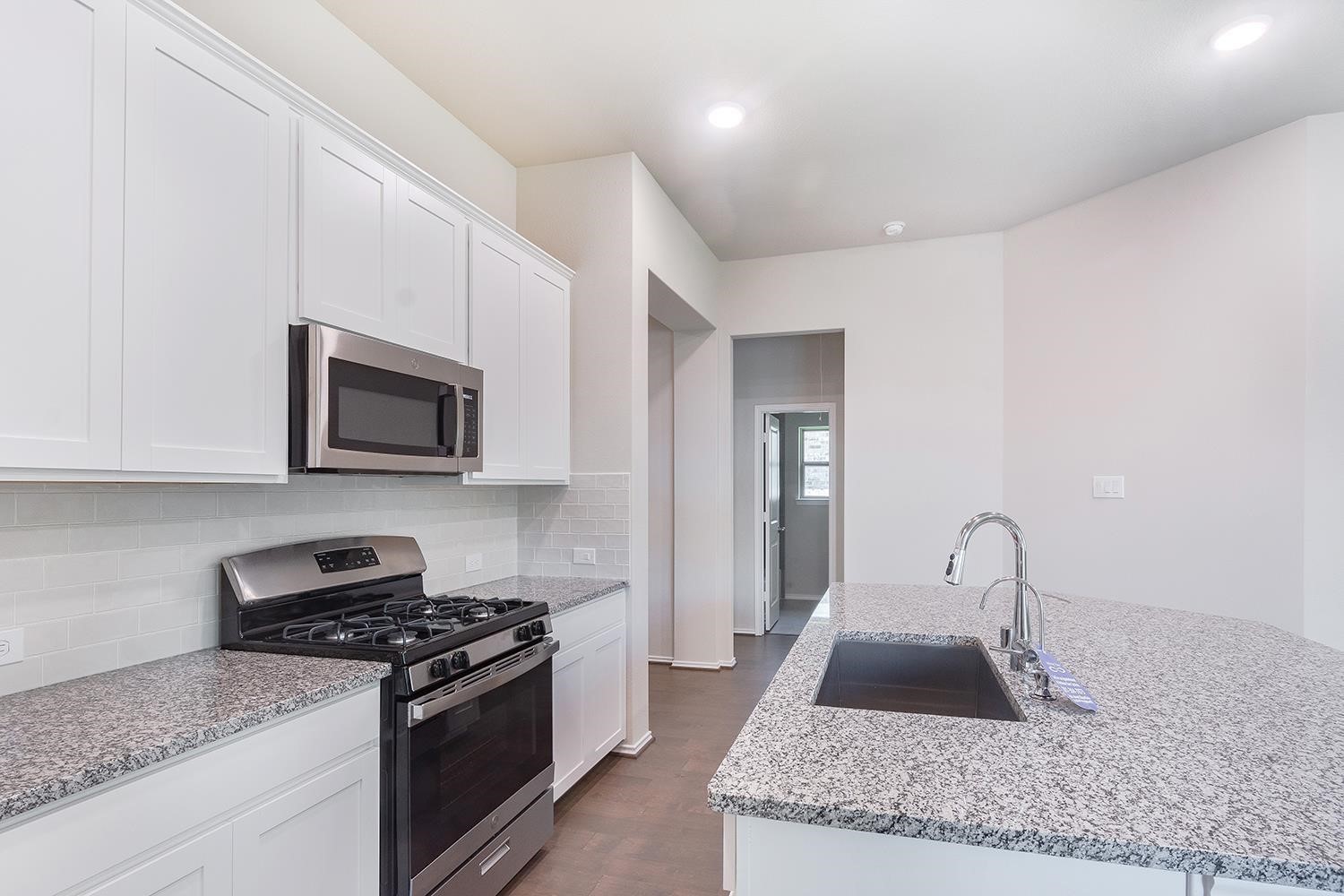 553 Timber Voyage Court Conroe, TX 77304 - Photo 11 of 31 a kitchen with sink stove and microwave