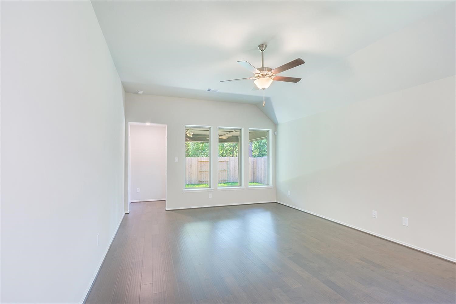 553 Timber Voyage Court Conroe, TX 77304 - Photo 12 of 31 an empty room with wooden floor fan and windows