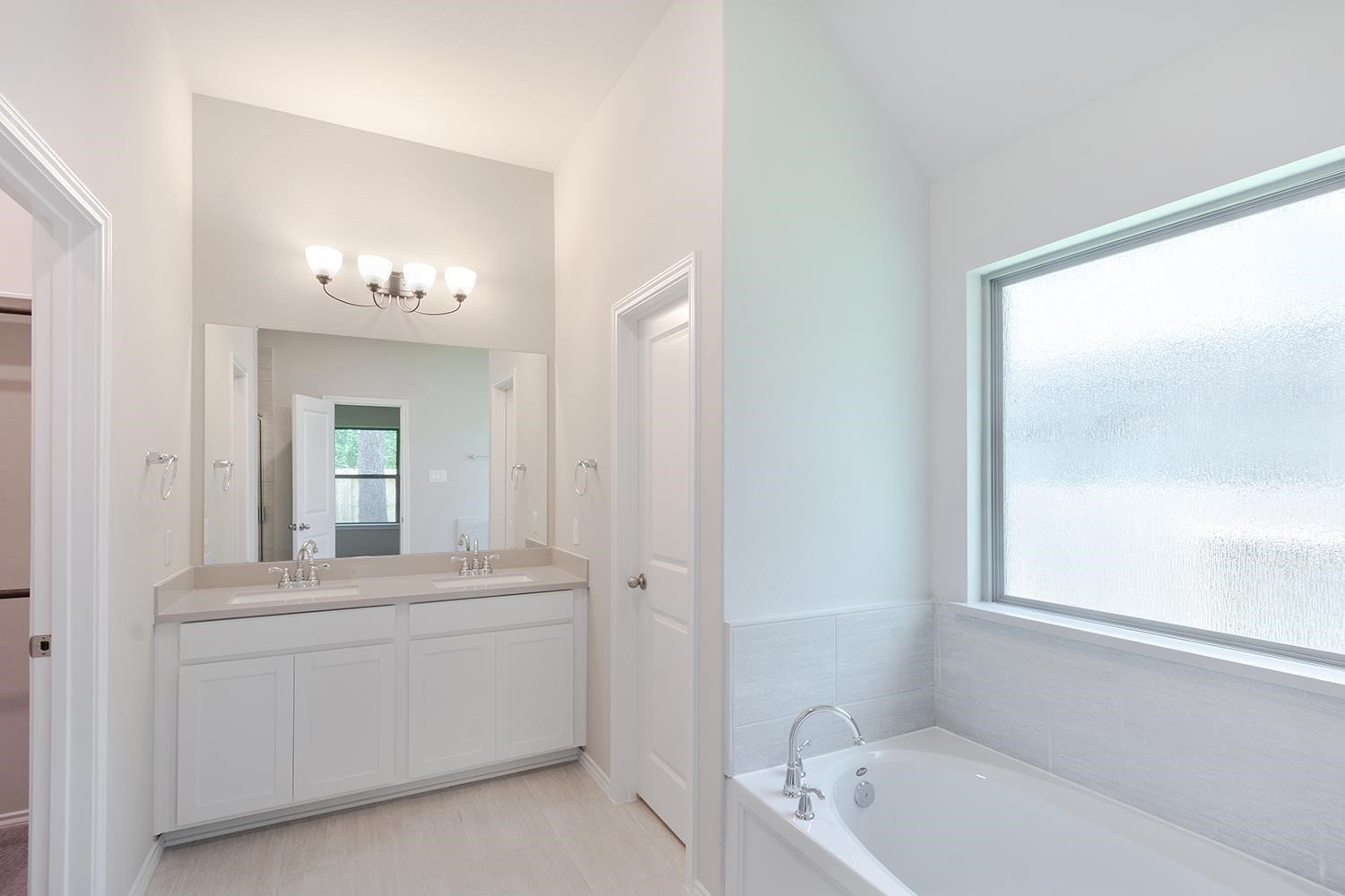 553 Timber Voyage Court Conroe, TX 77304 - Photo 16 of 31 a bathroom with a tub a sink and a mirror