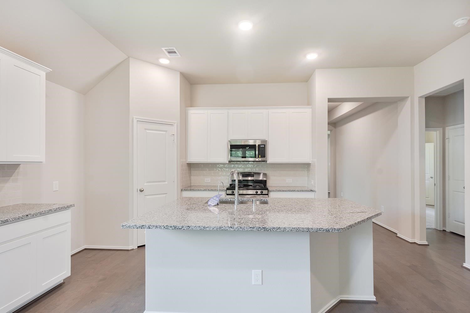 553 Timber Voyage Court Conroe, TX 77304 - Photo 7 of 31 a kitchen with kitchen island a sink stove and refrigerator