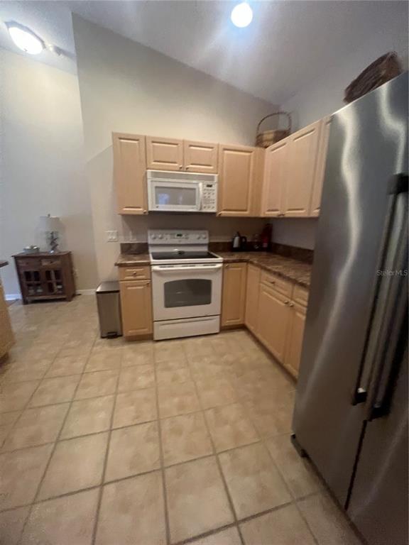 5373 Compass Point, Unit 1 Oxford, FL 34484 - Photo 11 of 38 a kitchen with stainless steel appliances granite countertop a stove a sink and a refrigerator