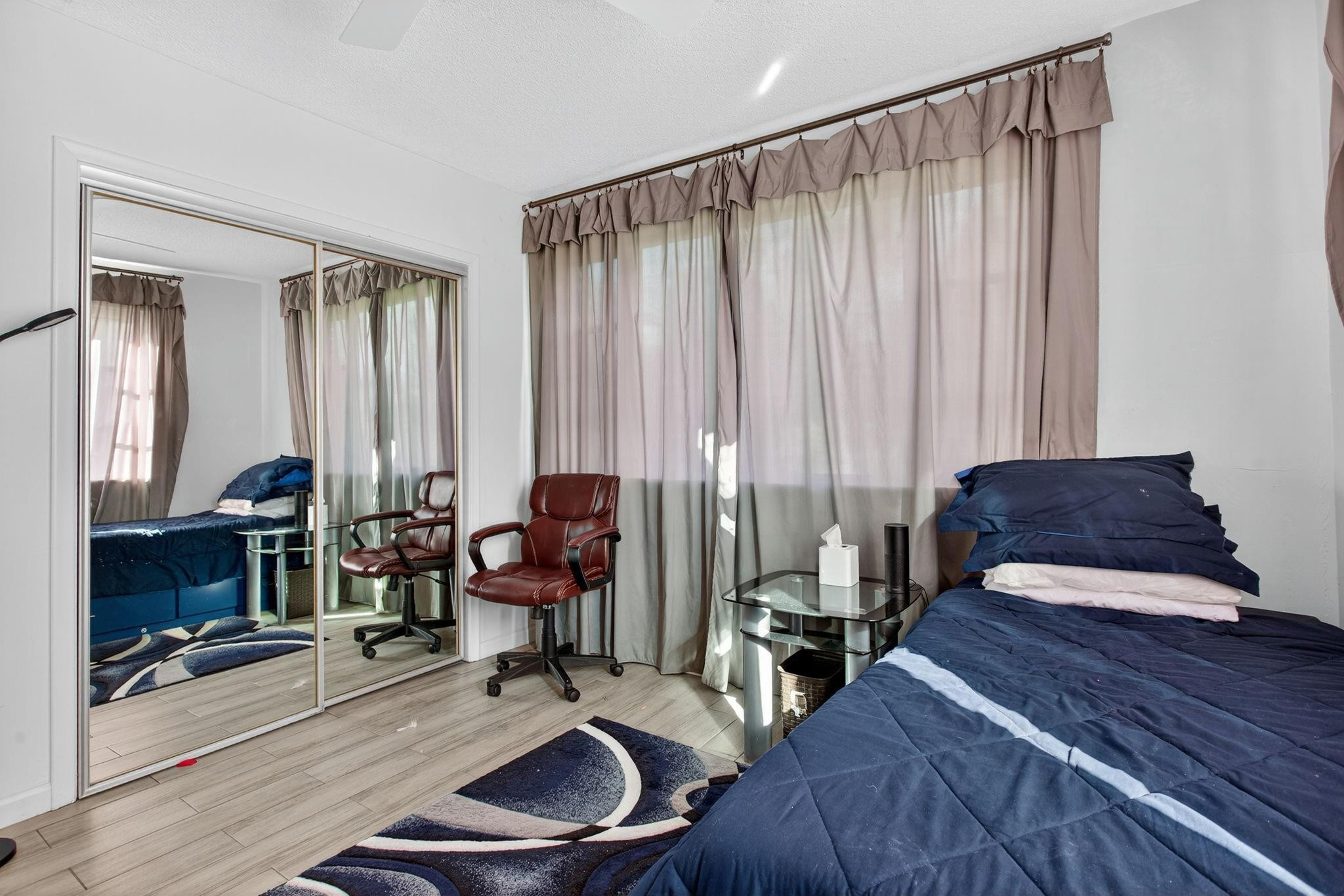 418 South Cypress Road, Unit 110 Pompano Beach, FL 33060 - Photo 19 of 28 a bedroom with furniture and large windows