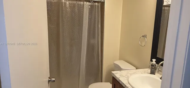 a bathroom with a sink and mirror with toilet