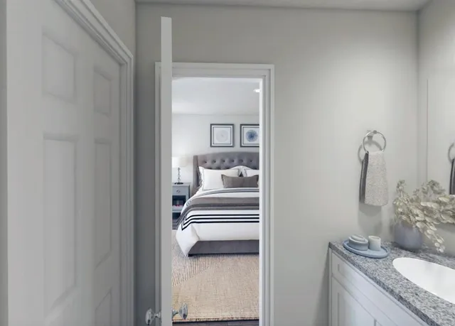 a en suite bathroom with a granite countertop sink and a mirror