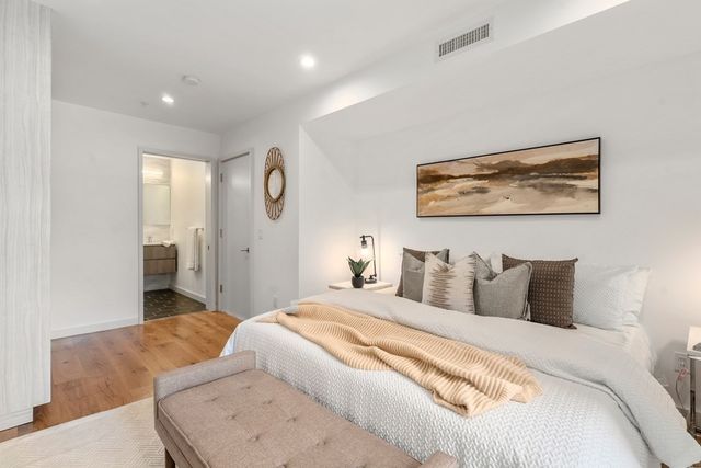 a bedroom with bed and a painting on the wall