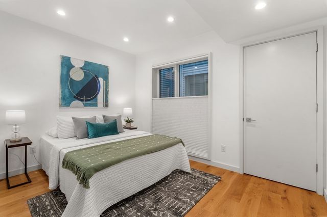 a bedroom with a bed and a painting on the wall