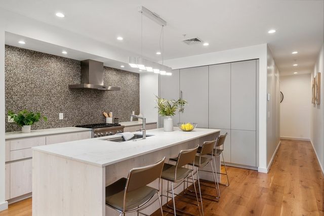 a kitchen with stainless steel appliances a sink a stove a refrigerator and cabinets