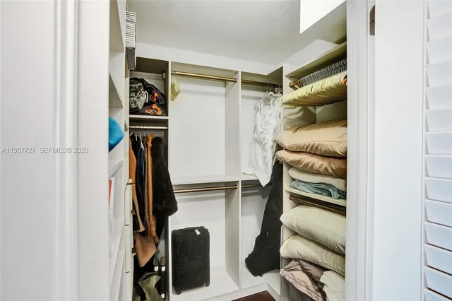 a view of walk in closet with clothes and shoes