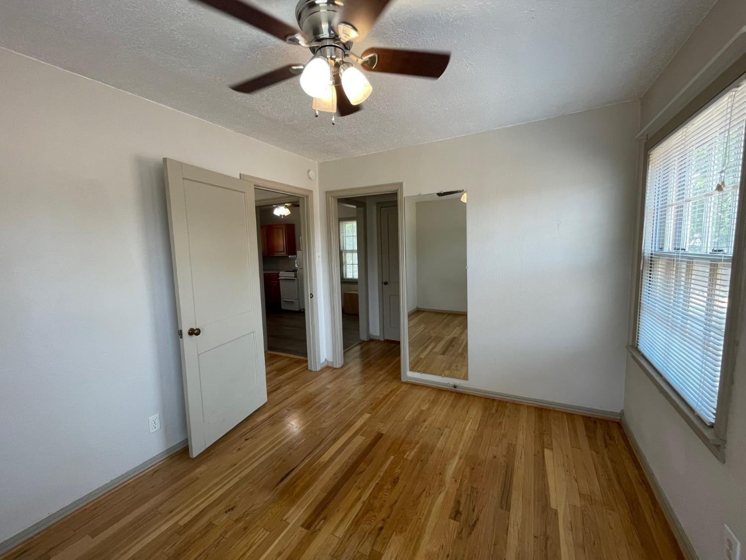 3018 29th Street Lubbock, TX 79410 - Photo 6 of 14 wooden floor in an empty room with a window