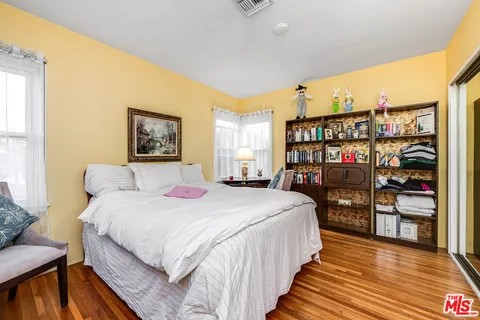 a bedroom with bed and a book shelf