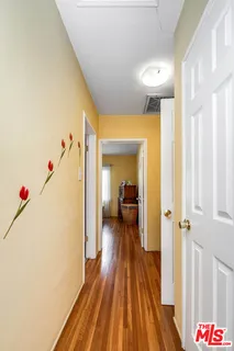 a view of a hallway with wooden floor and staircase