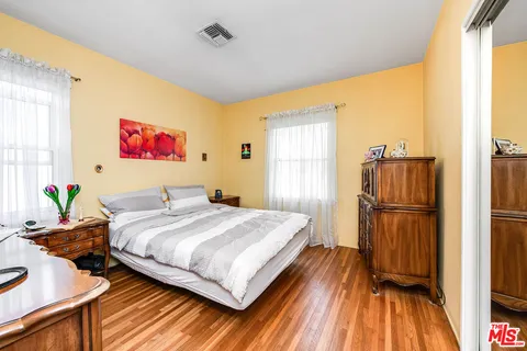 a bedroom with a bed and wooden floor
