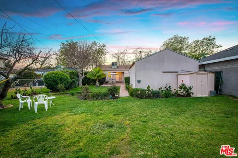 a view of a backyard with table and chairs and potted plants