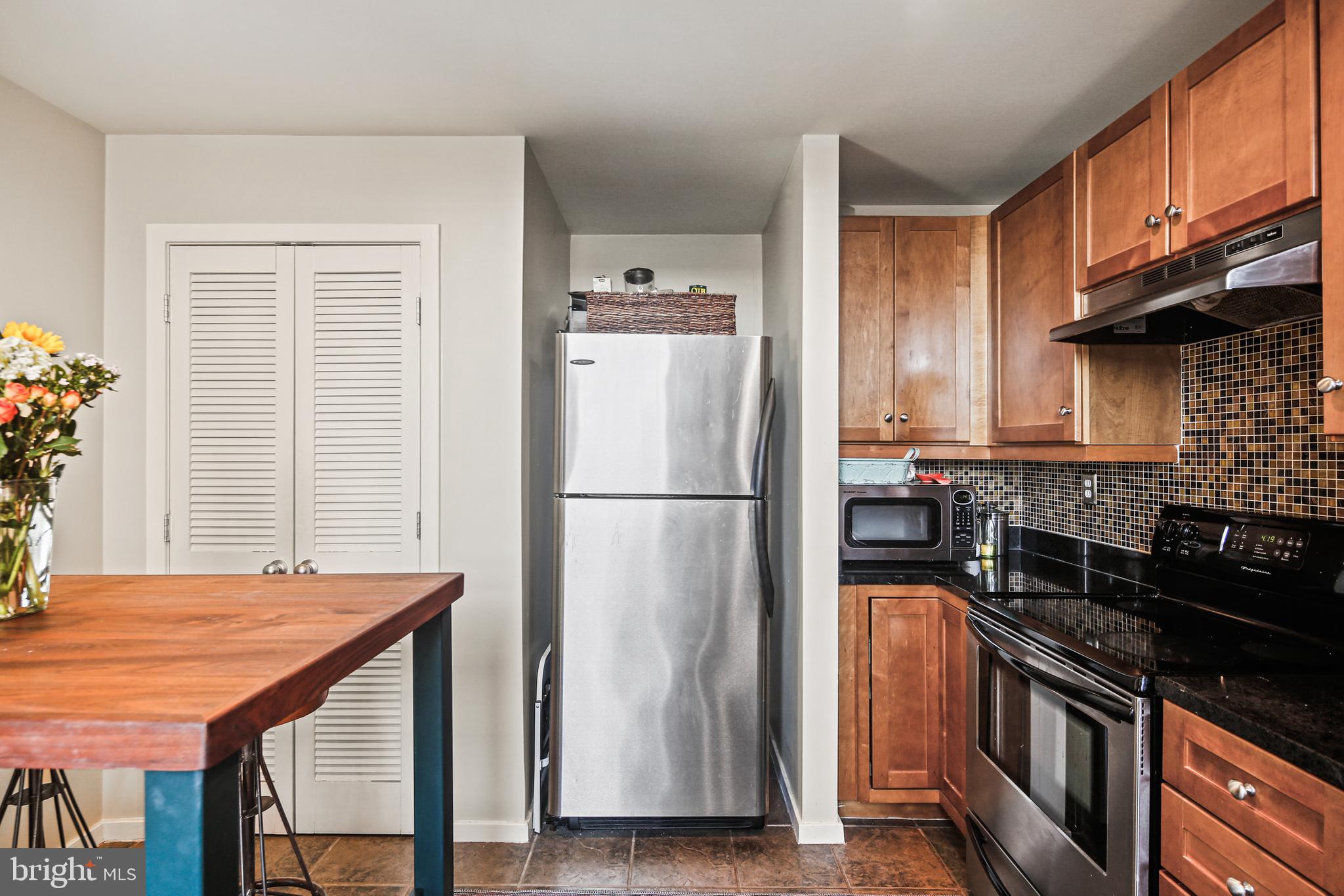 1211 Light Street, Unit 308 Baltimore, MD 21230 - Photo 13 of 29 a kitchen with stainless steel appliances granite countertop a refrigerator a stove and a sink with wooden floor