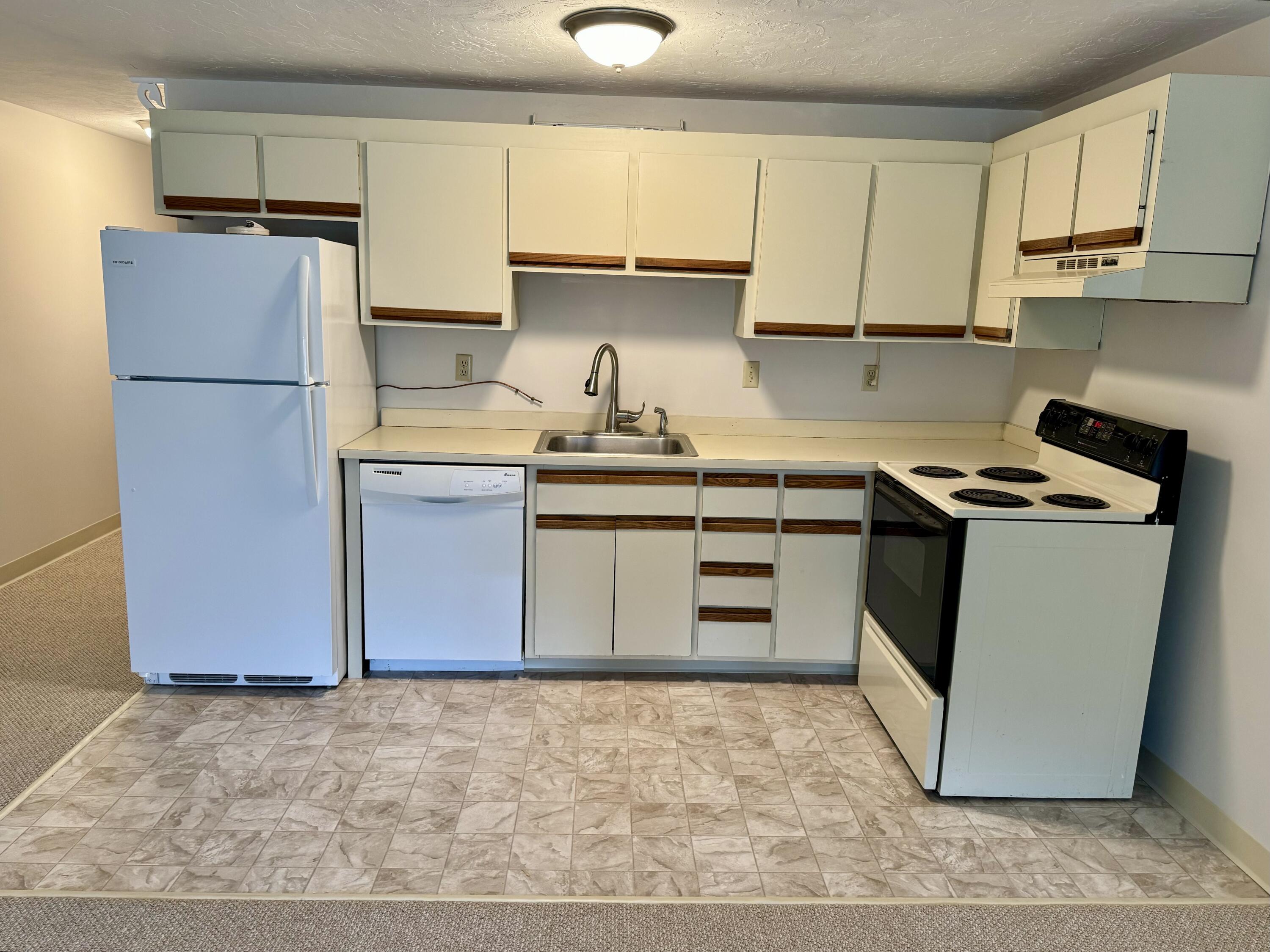 70 Cape Drive, Unit 1B Mashpee, MA 02649 - Photo 8 of 13 a kitchen with a stove sink and refrigerator