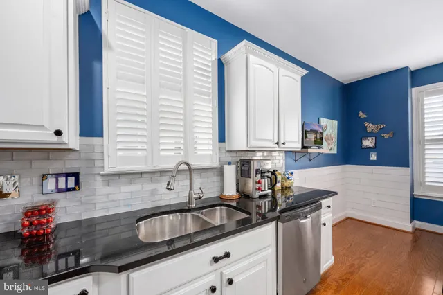 a kitchen with granite countertop a sink and a wooden floor