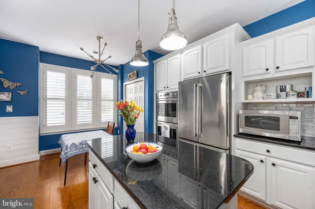 a kitchen with stainless steel appliances granite countertop a sink a stove and a refrigerator
