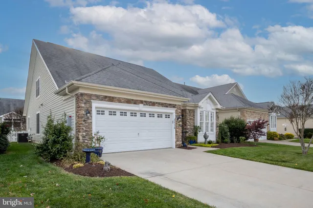 a front view of a house with a garden and garage