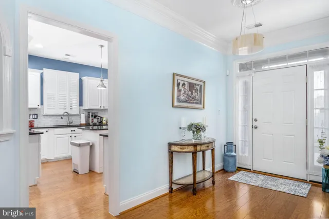 a open kitchen with white cabinets and wooden floor