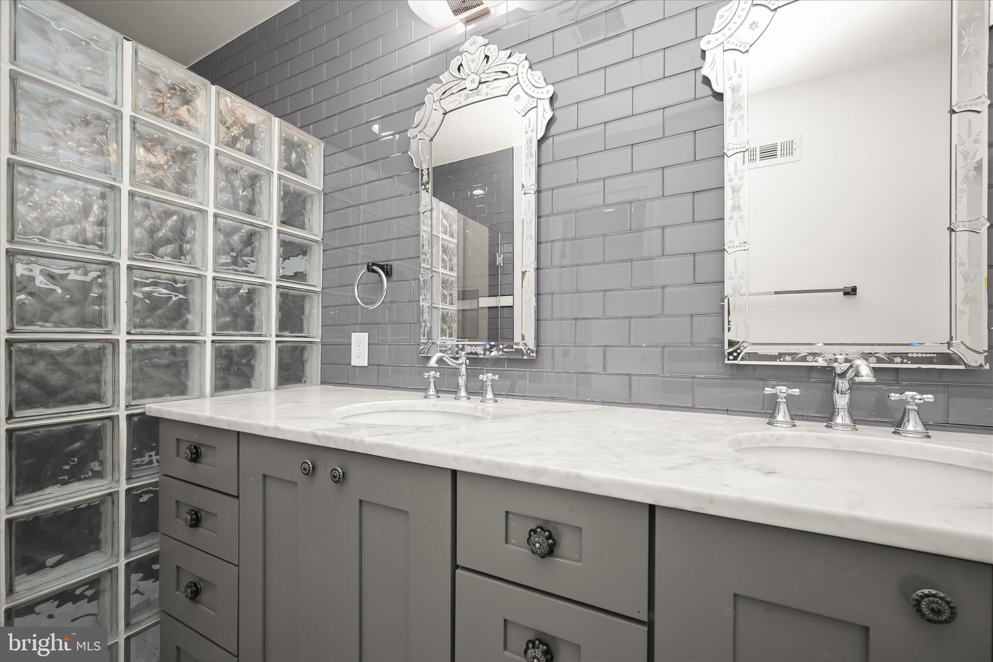7012 Exeter Road Bethesda, MD 20814 - Photo 70 of 103 a bathroom with a double vanity sink and a mirror