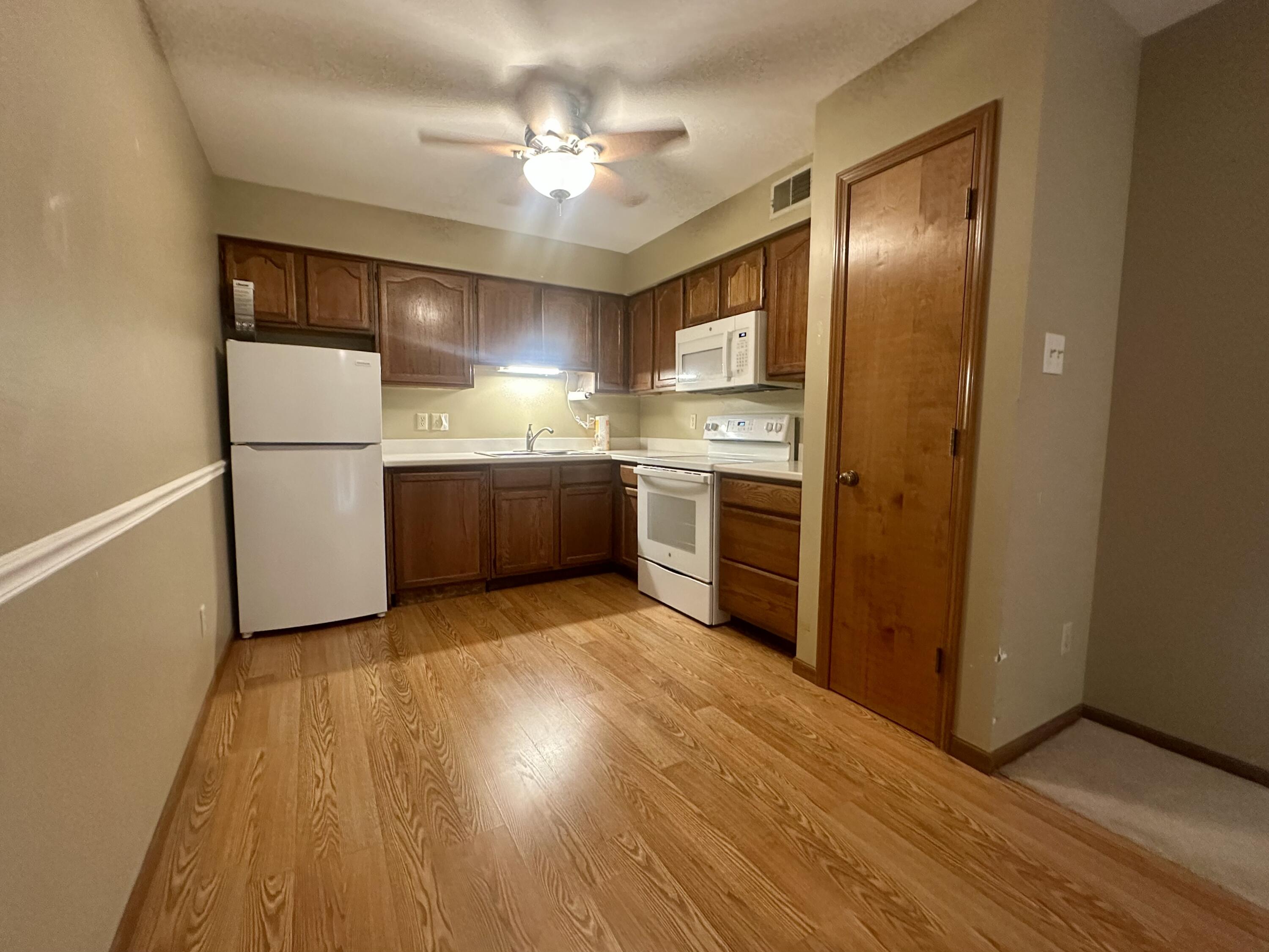 1079 Millpond Road, Unit A Valparaiso, IN 46385 - Photo 6 of 14 a kitchen with stainless steel appliances granite countertop a refrigerator a sink dishwasher and a stove with wooden floor