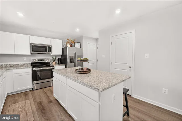a kitchen with granite countertop a sink stove and refrigerator