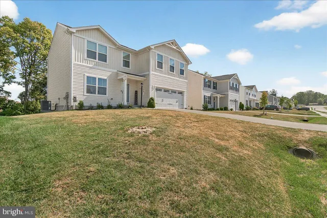 a large white building with a big yard and large trees
