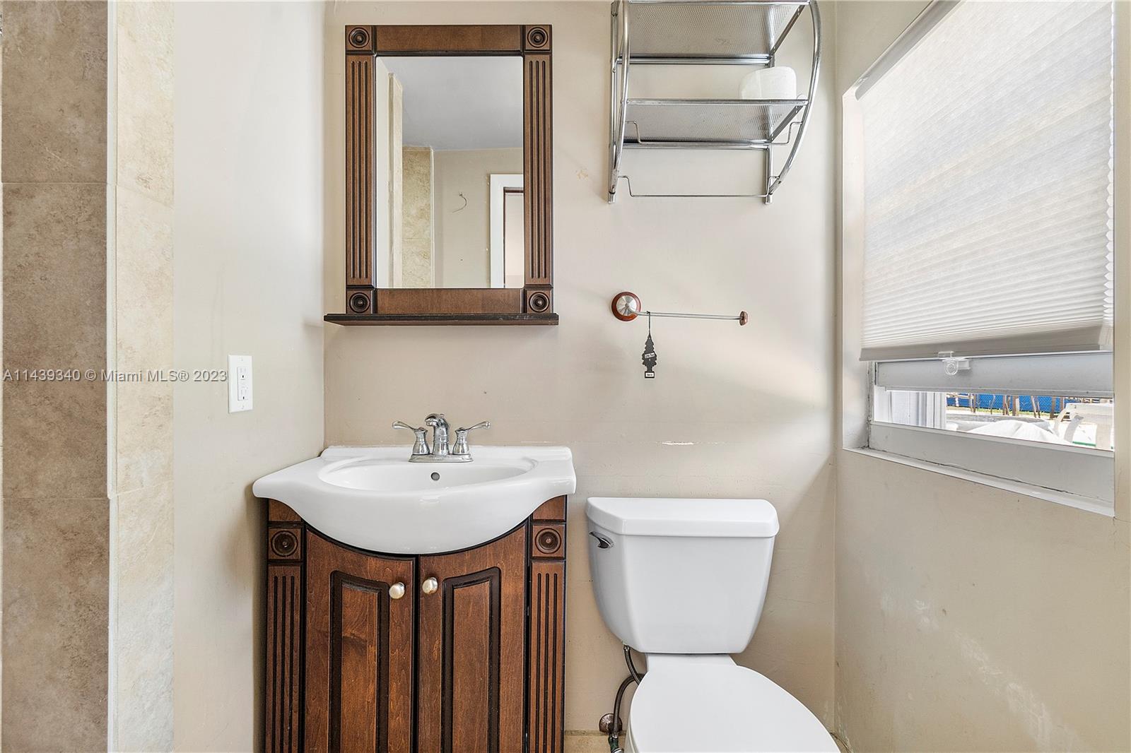 18201 Spring Road Southwest Ranches, FL 33331 - Photo 27 of 29 a bathroom with a sink a toilet and mirror