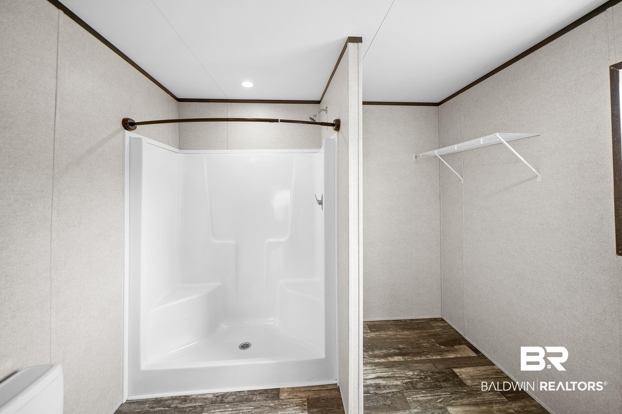 21601 Westside Loop Silverhill, AL 36576 - Photo 23 of 42 White shower enclosure with built-in seating and a curved shower rod