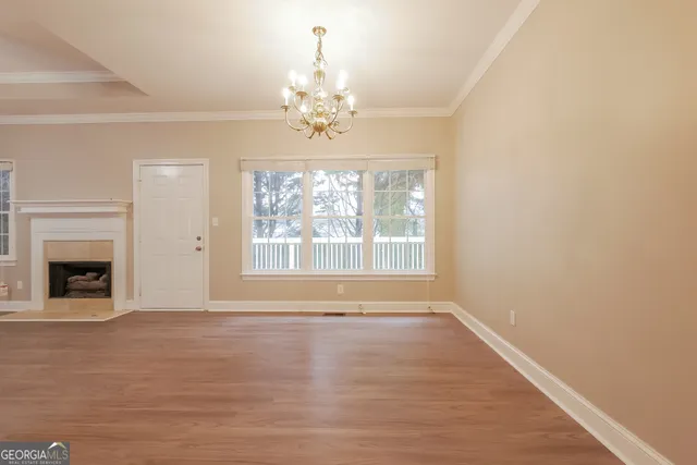 a view of an empty room with window and fire place