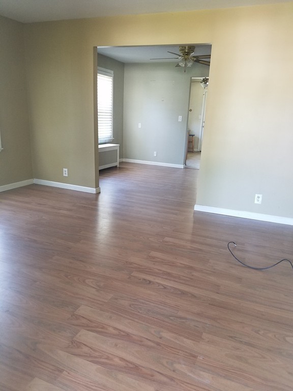 52 Stuart Street Springfield, MA 01109 - Photo 5 of 14 a view of an empty room with wooden floor and a window