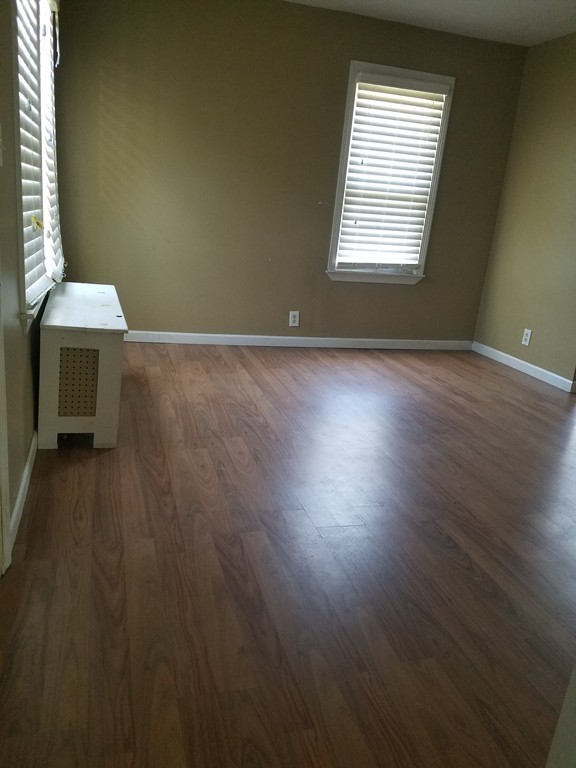 52 Stuart Street Springfield, MA 01109 - Photo 8 of 14 an empty room with wooden floor and windows