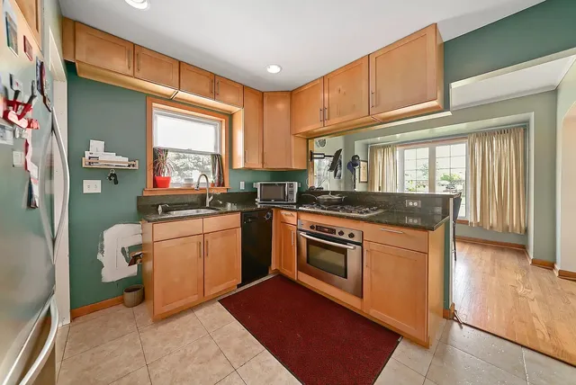 a kitchen with stainless steel appliances granite countertop a sink stove and cabinets
