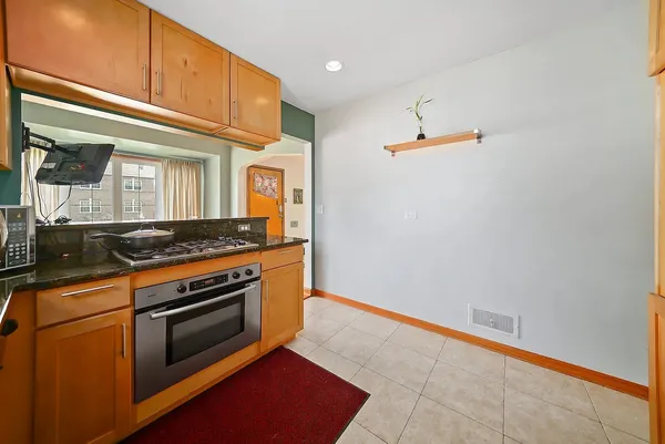 a kitchen with granite countertop cabinets stainless steel appliances and a counter space