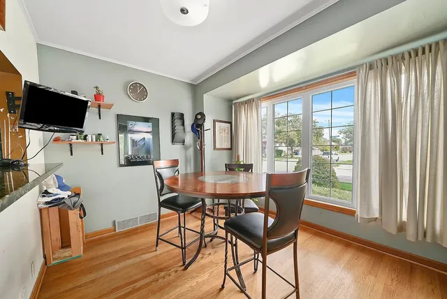 a dining room with furniture window and wooden floor