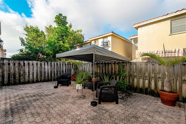 a backyard of a house with barbeque oven table and chairs