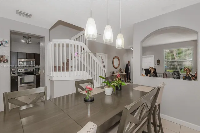 a view of a dining room and kitchen with furniture and large windows