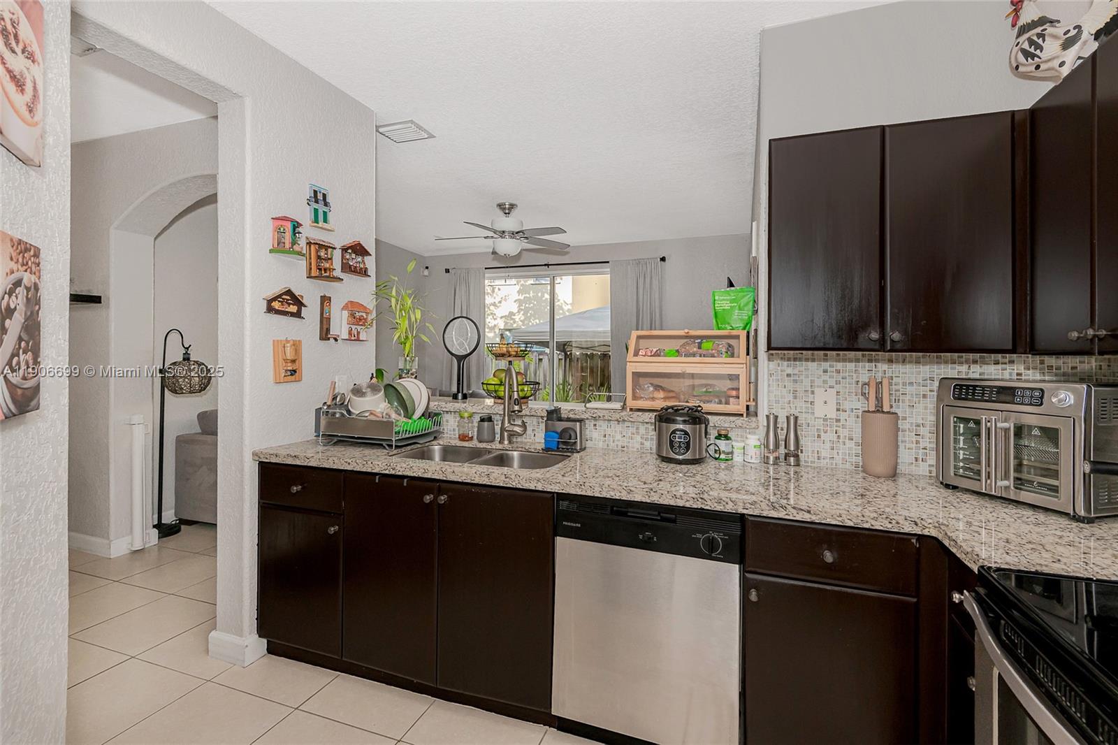 3816 Southwest 169th Terrace Miramar, FL 33027 - Photo 8 of 21 a kitchen with stainless steel appliances granite countertop a sink stove and refrigerator