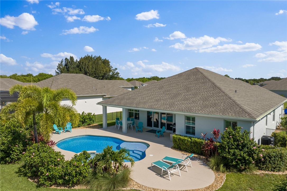 7203 33rd Square Vero Beach, FL 32967 - Photo 1 of 28 a view of a white house with a yard plants and large tree