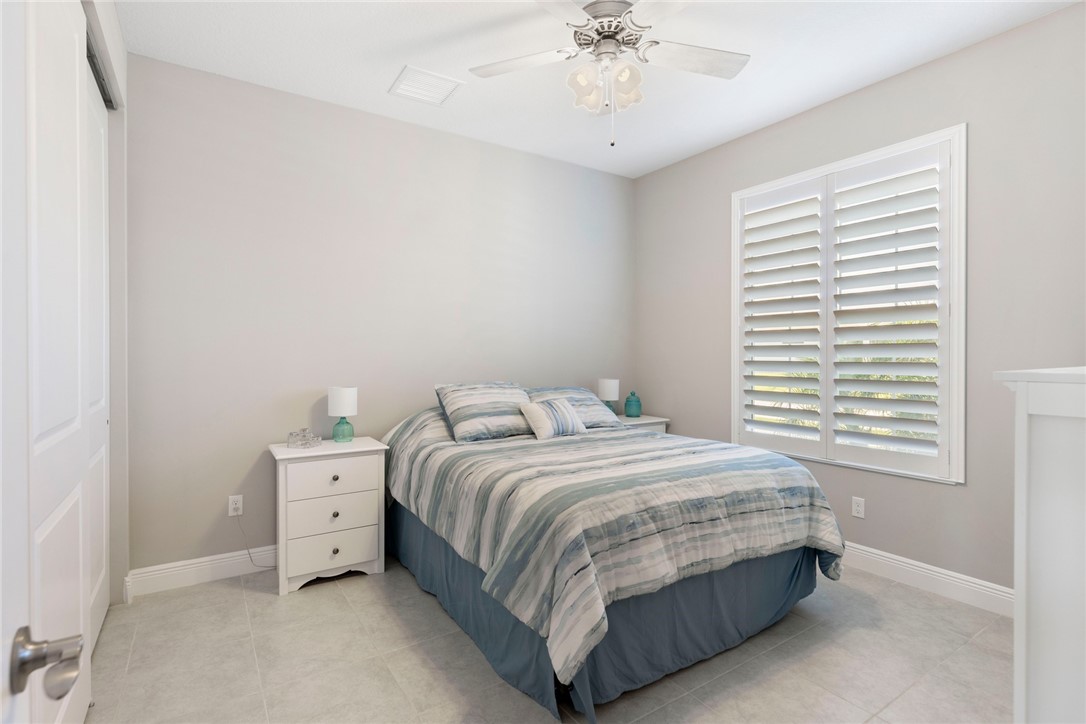 7203 33rd Square Vero Beach, FL 32967 - Photo 13 of 28 a bedroom with a bed and a chandelier