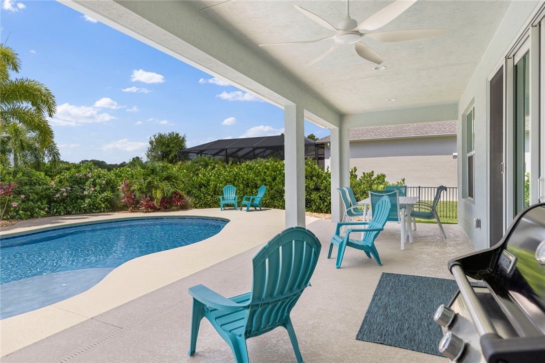 7203 33rd Square Vero Beach, FL 32967 - Photo 20 of 28 a view of a patio with couches chairs potted plants and floor to ceiling window