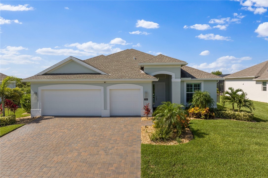 7203 33rd Square Vero Beach, FL 32967 - Photo 2 of 28 a front view of a house with a yard and garage