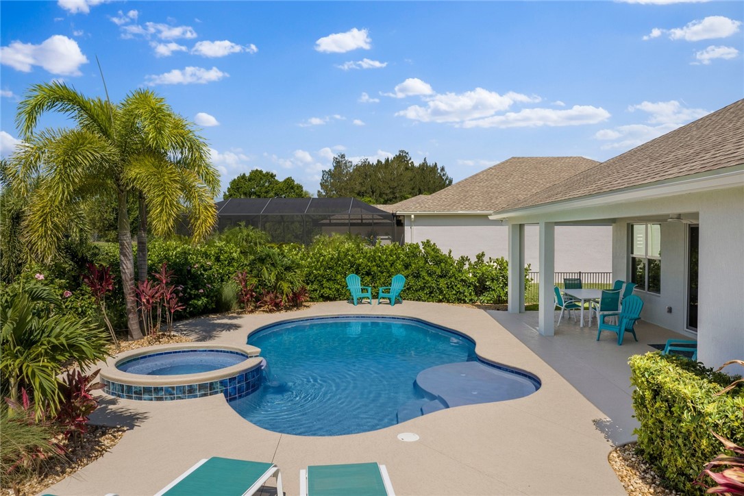 7203 33rd Square Vero Beach, FL 32967 - Photo 24 of 28 a view of a patio with table and chairs potted plants and palm tree