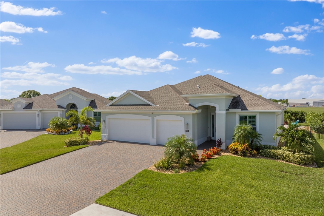 7203 33rd Square Vero Beach, FL 32967 - Photo 27 of 28 a front view of a house with a yard and garage