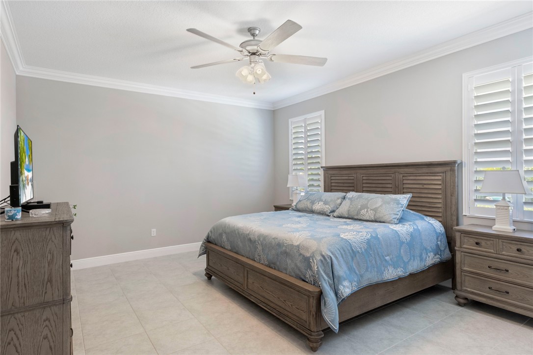7203 33rd Square Vero Beach, FL 32967 - Photo 10 of 28 a bedroom with a bed and a flat tv screen on dresser