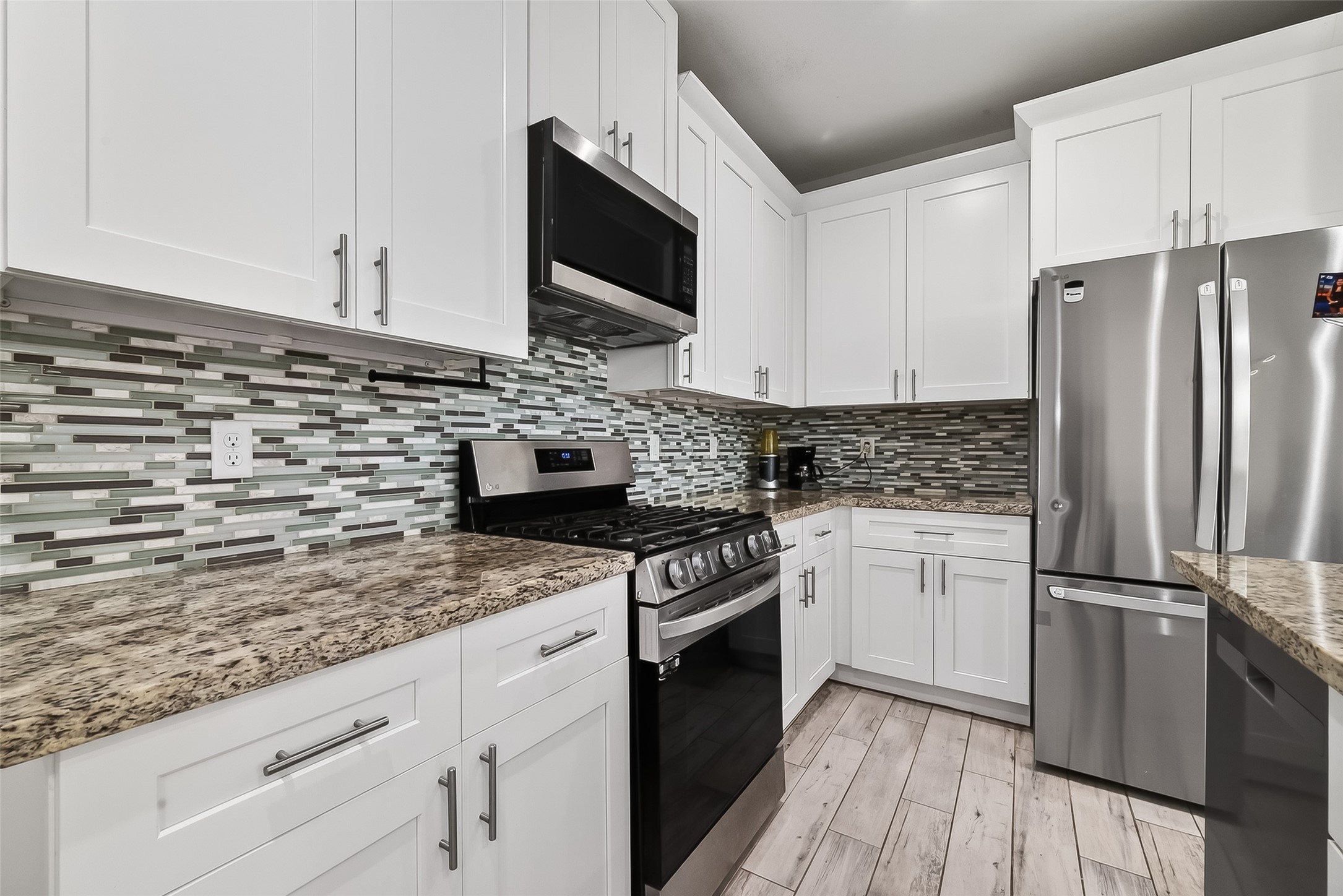 1411 Featherstone Street, Unit B Houston, TX 77020 - Photo 11 of 32 a kitchen with granite countertop a sink stove and refrigerator